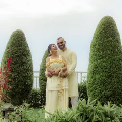 A moment of quiet connection amidst the Haldi fun. Niharika and Aaron share a laugh in the misty mountain air of Solan, their yellow outfits perfectly complementing the lush green surroundings.