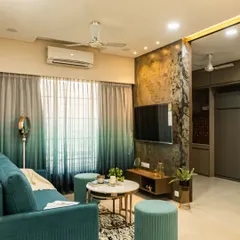 This living room features a stunning stone veneer TV wall that adds natural texture and a dramatic focal point. The teal sofa and ombre curtains bring in a splash of color, creating a balanced and stylish look.