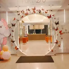 An elegant entrance arch designed for a Puravankara corporate event. The clean white circular arch is decorated with butterfly cutouts, creating a sophisticated and welcoming entrance for guests.