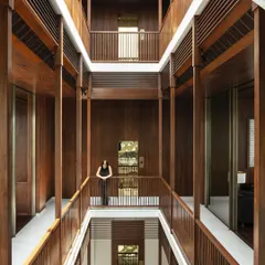Inspired by the traditional Indian 'wada' or courtyard house, this multi-level atrium forms the heart of the home. Clad in warm timber, it creates visual and aural connections across floors, allowing light and life to flow through the entire structure, fostering a sense of togetherness for the family.