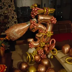 A close-up of the detailed balloon sculpture for the 3rd anniversary. I crafted the number '3' and a champagne bottle from twisting balloons, adding small floral balloon accents for a more intricate look.