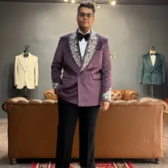 Our client Mr. Harshit radiates confidence in a custom-made purple velvet tuxedo. The lapels and cuffs are adorned with intricate silver hand embroidery, making it a standout choice for his special event.