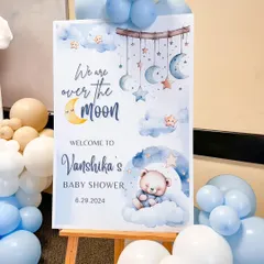 A beautifully designed welcome sign for a teddy bear themed baby shower, placed on an easel and surrounded by matching balloons.