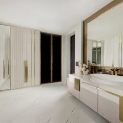 A master suite designed for slow rituals. This view shows the seamless flow from the walk-in wardrobe with fluted glass doors into the master washroom, where a matching fluted vanity and marble floors create a cohesive, luxurious feel.