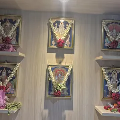 A still shot of the set of 6 paintings in our client's pooja room. The arrangement with fresh flower garlands enhances the devotional atmosphere.