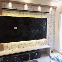 A modern geometric wallpaper with a clean, white background and thin gold lines, installed as a stylish backdrop for a TV unit. This design adds a touch of contemporary elegance without overwhelming the space.