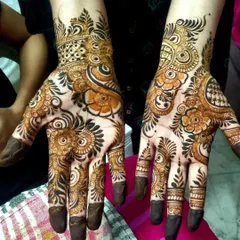 A classic Indo-Arabic design. The bold outlines and shaded florals create a strong visual impact, while the delicate netting on the fingers adds a touch of intricacy.