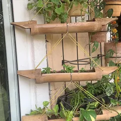 For this balcony, I created a vertical planter using sections of natural bamboo. This setup is ideal for growing herbs or small trailing plants, making efficient use of a narrow wall space.