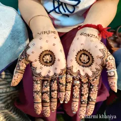 Let your hands do the talking. This design features a central lotus mandala with the couple's names, Virendra and Soniya, written above. The fingers are adorned with beautiful floral patterns.