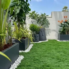 A beautifully finished terrace garden featuring lush artificial turf, modern planters, and decorative white pebbles. This demonstrates my eye for detail and ability to create complete, aesthetically pleasing outdoor living areas.