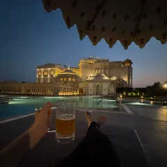 Capturing the serene moments of a luxury hotel stay. This shot from the Fairmont Jaipur shows the stunning poolside ambiance at dusk, selling an experience of relaxation and opulence that goes beyond just a room.