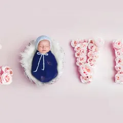Look at this little angel, all snuggled up. I created the word LOVE using soft pink flowers to frame the baby, making for a super sweet and classic newborn portrait. It’s a simple, beautiful way to celebrate your new love.