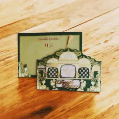 A love story deserves a grand beginning. This elegant laser-cut wedding invitation is crafted on a premium MDF base, featuring an intricate palace design with a tassel detail.