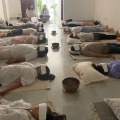 Deep rest during a sound bath. Participants lie in Savasana, covered and comfortable, allowing them to fully receive the vibrational healing and achieve a state of profound relaxation.