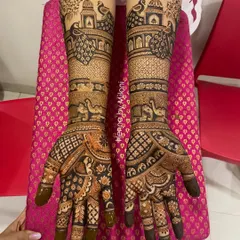 This bridal design is a symphony of peacocks and palaces. The bold, dark-filled peacocks stand out against the finer, more delicate patterns covering the rest of the hands.
