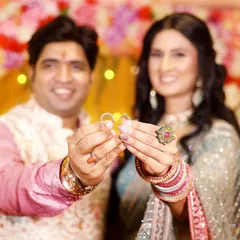 The moment of exchange. This photo focuses on the couple holding up their engagement rings, a clear and joyful symbol of their new beginning.