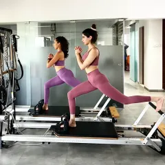 Pilates is even better with a partner. Here, Khushi Kapoor and our founder Namrata Purohit perform a synchronized lunge on the reformer, showcasing perfect form and coordination. Partner workouts add a fun, motivational dynamic to your fitness routine.