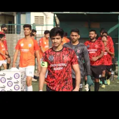 Our team captain, wearing the red and black away kit, leads the players onto the pitch with focus and determination during the Republic Cup finals.