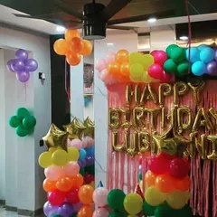 This view shows how the classic balloon decorations can transform a room corner. I use balloon clusters on the walls and ceiling to complement the main backdrop, creating a full party atmosphere.