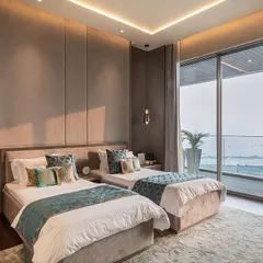 A residential interior in Bandra that masterfully combines luxury with comfort. The design uses deep blue furnishings to contrast with warm wooden elements, while bespoke pendant lights and sculptural accents add a refined character to the space.