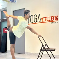Another angle of the chair-assisted Natarajasana. The chair provides stability, allowing you to focus on opening the shoulder and quadriceps.