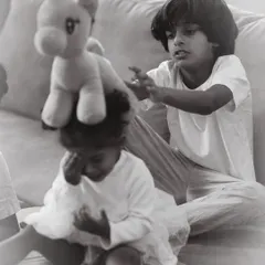 The funny, unpredictable interactions between siblings are what make family photoshoots so special. Here, an older brother playfully balances a toy on his little sister's head, a perfect example of an authentic, unscripted memory.