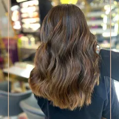 A perfect example of our custom-blended brunette balayage. We used a freehand painting technique to create these seamless, sun-kissed ribbons of colour, styled with loose waves for a natural, lived-in feel.