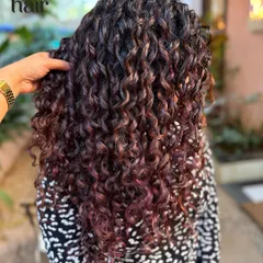 You don't always need bleach for a big impact. Here, we used a no bleach hair colour to create these rich, dimensional purple and red tones, finished with our signature finger coiling technique for maximum definition.