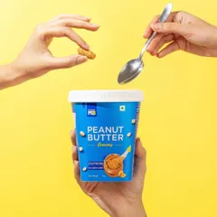 This conceptual hand model shot for a peanut butter brand is playful and creative. The composition suggests the ingredients are being magically added, turning a simple product into something more exciting.