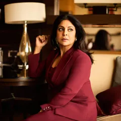 Seated in a lounge, this image exudes quiet confidence, with the rich color of the suit standing out.