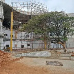 A construction photo from the Inorbit Vizag site, where the building's form curves to accommodate an existing tree. This demonstrates our principle of letting the site lead the design and preserving natural assets.