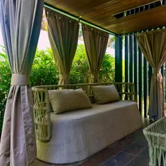 This private gazebo in Jaipur, draped with curtains, offers a shaded and secluded seating area. It’s a perfect example of creating a comfortable outdoor room within a larger garden.