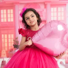 Pretty in pink for her Barbie-themed photoshoot. Her sweet smile and beautiful dress make this a picture-perfect moment.
