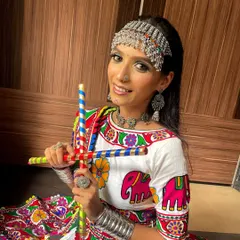 Ready for Garba! This shot features the model with dandiya sticks, capturing the joyful and energetic spirit of Navratri. The makeup is bright and long-lasting for a night of dancing.