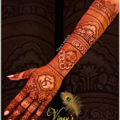 A personalized back-of-hand design featuring the couple's initials 'S' and 'G'. The design extends up the arm with architectural and elephant motifs.