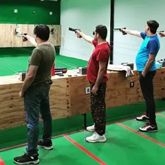 Three shooters focusing on their targets with air pistols. This shows the classic 10-meter pistol shooting stance that I teach all our first-timers.