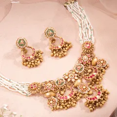 The Chaandbali Takkar Set feels like wearing a piece of moonlit celebration. Crescent silhouettes are detailed with rich red and green enamel, finished with clusters of golden beads that echo stories of festive nights and palace courtyards.