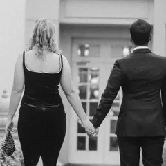 A beautiful shot of the couple walking away hand-in-hand. This black and white photo from their pre-wedding session has a classic, cinematic feel, symbolizing the start of their journey together.