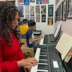 An ongoing keyboard session at our studio. You can see students of different ages focused on their practice, with an instructor nearby to provide guidance.