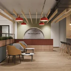 A 3D render of a warm and inviting cafeteria space. The design uses a mix of wood tones, soft lighting, and varied seating like lounge chairs and bar stools to create a comfortable environment for employees to unplug.