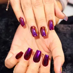 This isn't just purple, it's a whole mood. These coffin-shaped nails are coated in a stunning multichrome polish that shifts from a deep, metallic purple to a fiery red-orange depending on the light.