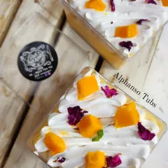 These individual Alphonso Mango Tubs are a perfect single-serving dessert. They feature layers of light cake, whipped cream, and fresh mango puree, topped with mango chunks and edible flowers.