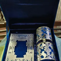 This is an example of a truly luxurious wedding invitation set. It features an intricate silver laser-cut card and matching favors, all presented in a royal blue velvet box, designed to be a treasured keepsake.