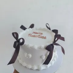 A "Hello Twenties" vintage cake with brown ribbons, a perfect way to celebrate a milestone birthday in style.