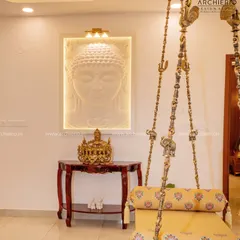 A serene corner where spirituality meets tradition. The back-lit Buddha wall art creates a peaceful focal point, complemented by the intricate brass details of the traditional Indian swing.