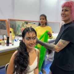 Behind the scenes at a hair show, getting one of our models ready. There's so much energy, creativity, and teamwork that goes into every look we present. This is us in our element.