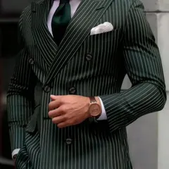 A dark green pinstripe double-breasted suit that exudes confidence. The fit is impeccable, showcasing how a well-tailored suit can elevate your entire presence.