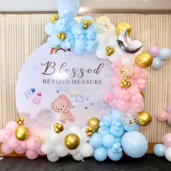 A "Blessed Beyond Measure" baby shower backdrop. This circular backdrop is framed with pink, blue, and gold balloons, perfect for a gender reveal or a neutral-themed celebration.