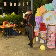 Performing the appearing dove trick at an outdoor unicorn themed birthday party. The natural light and open space add a unique charm to the magic.