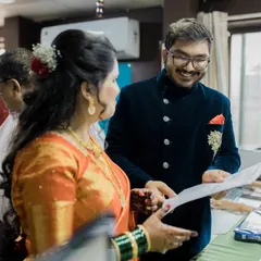 A candid shot of the couple smiling as they review their marriage documents, a key moment in their official union.